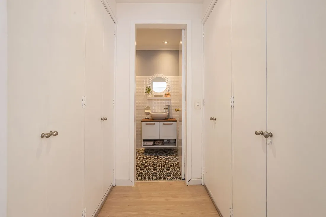 Vue en coupe d'un studio rangé avec zones entrée, coin nuit, cuisine et séjour bien délimitées